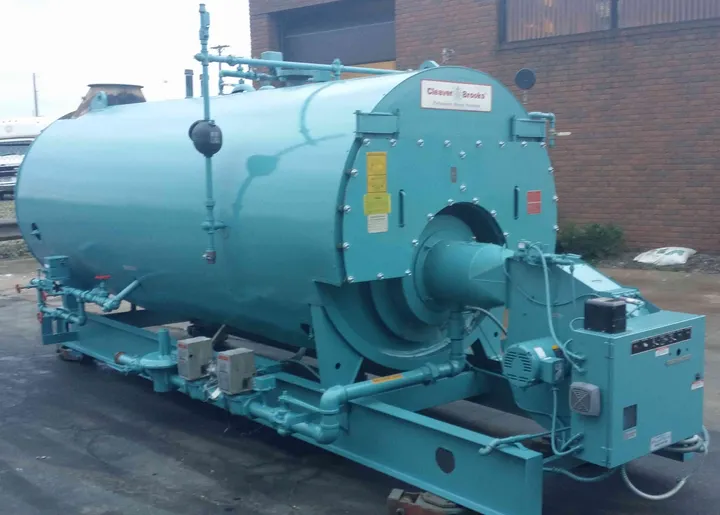 Skid-mounted Cleaver-Brooks firetube steam boiler with burner and gas train staged outside the shop