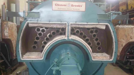 Cleaver-Brooks firetube boiler opened at the front head, exposing the tube sheet during a retube